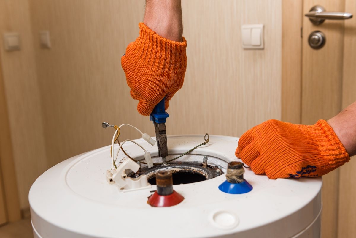 Plumber hands tighten bolts of water heater